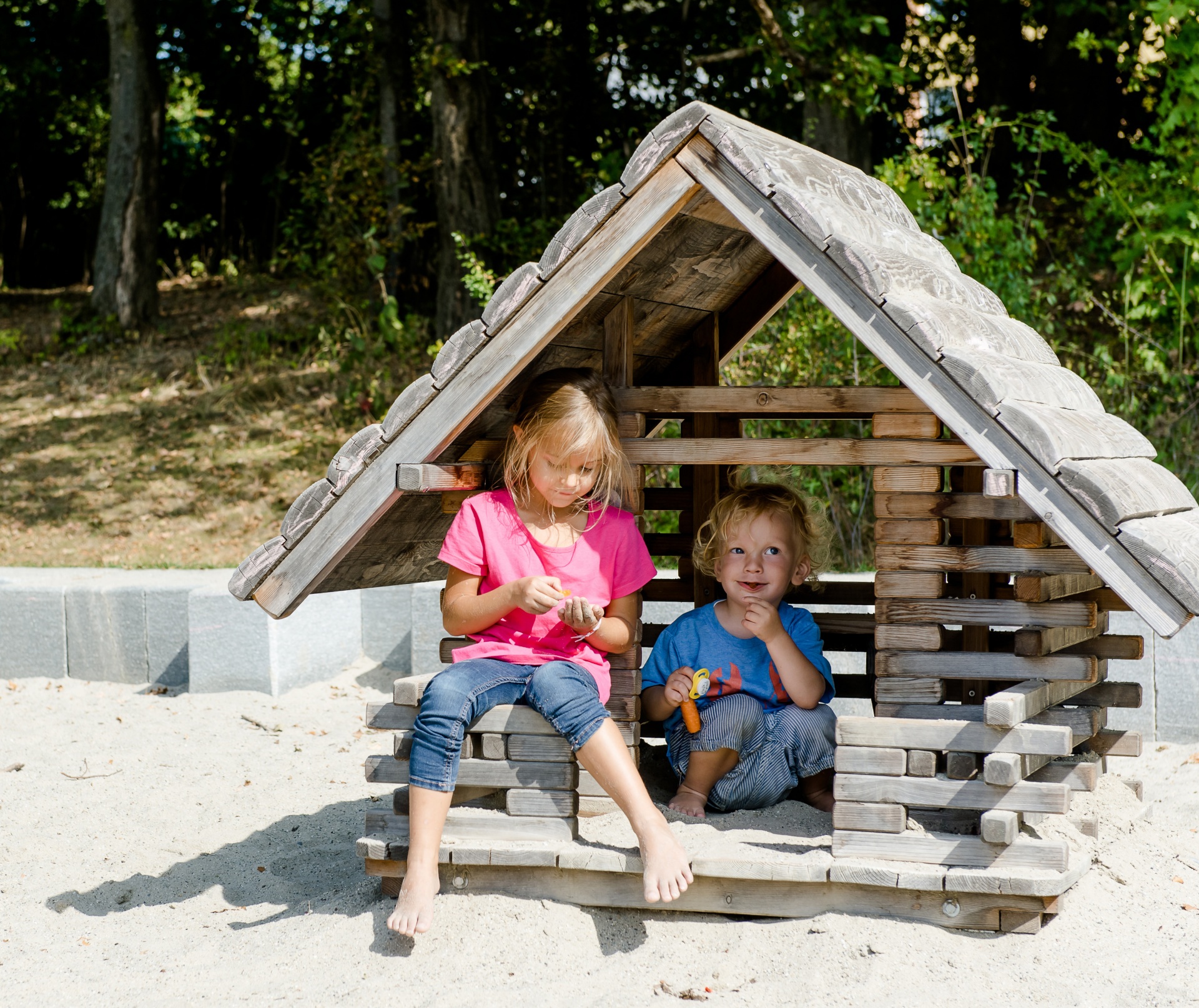 Kinder mit unterschiedlichem Alter spielen auf Waldspielplatz